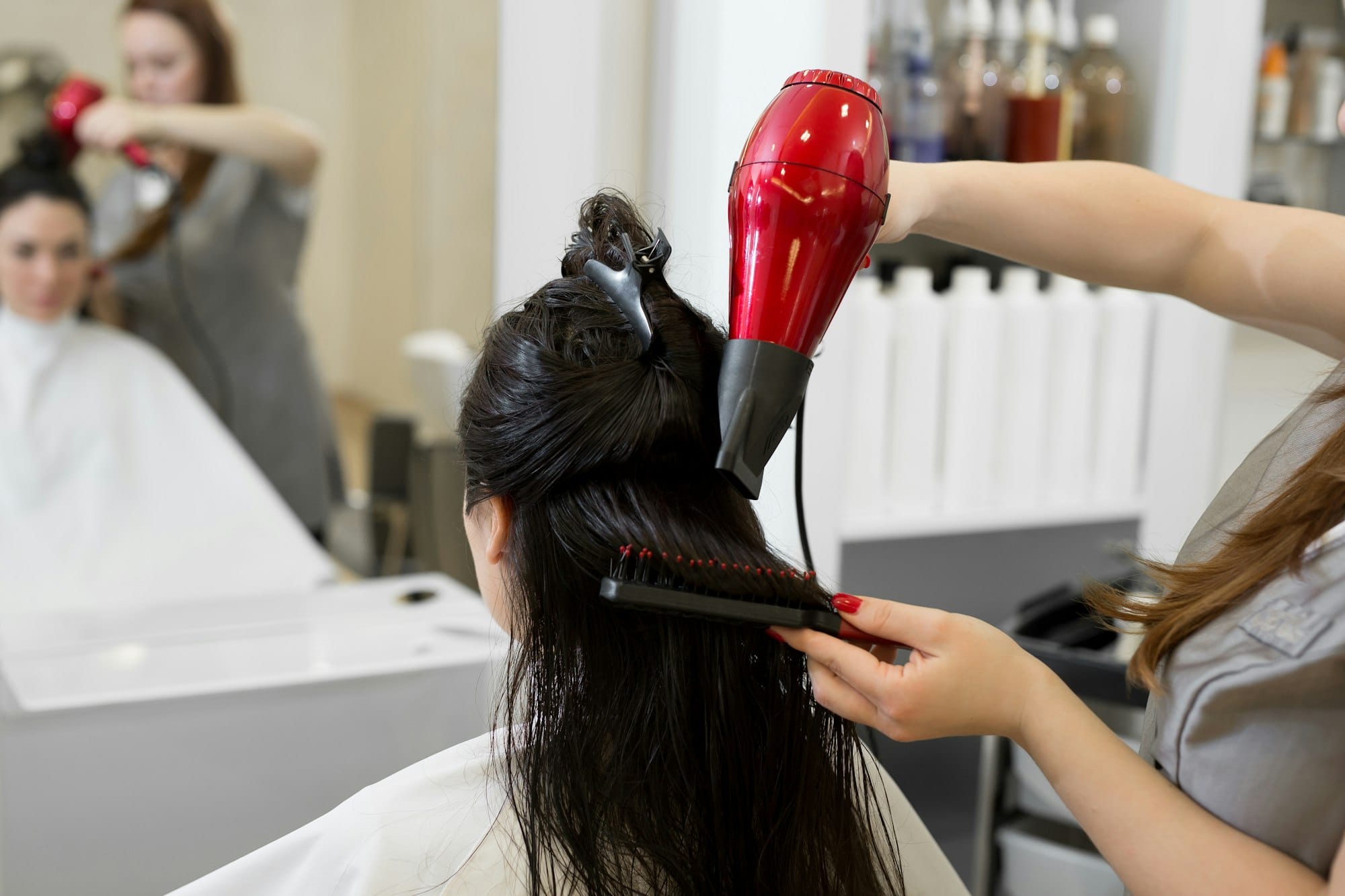 Hair stylist work on woman hairstyle in salon.